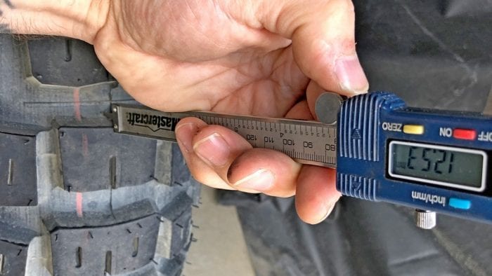 Measurement of tread depth on the rear Motoz Tractionator Adventure Tire.