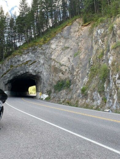 A Harley Davidson parked in front of a tunnel.