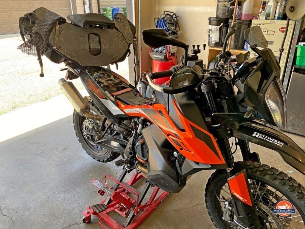 The Mosko Moto Reckless 80L V3.0 Revolver half removed from a KTM 790 adventure to access under the seat.