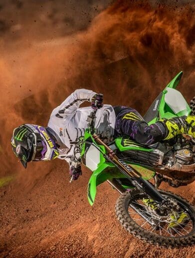 A side profile of a rider trying out the new 2022 Kawasaki KX450SR edition on a track