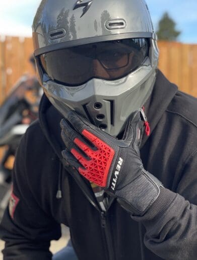 Rider wearing REV'IT Sand 4 Gloves in black and red with Scorpion Covert X helmet