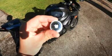 A view of an Apple AirTag next to a motorcycle