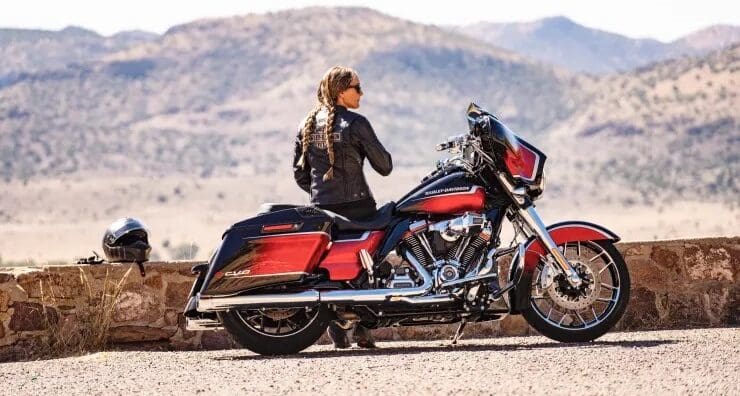 A woman in the desert next to a motorcycle. Photo sourced from CNBC.