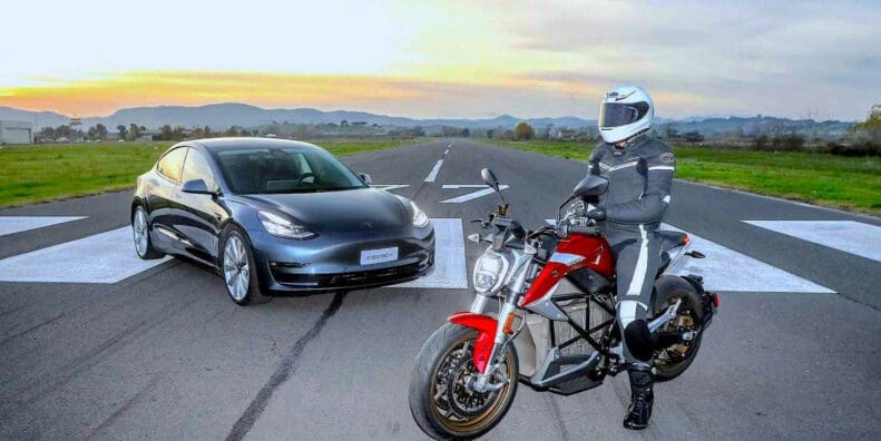 A Tesla about to duel against an EV motorcycle. Media sourced from InsideEvs.