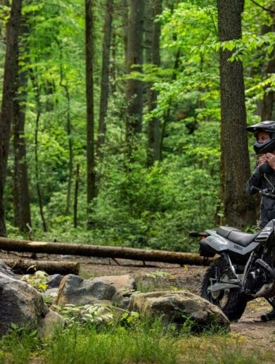 A Yamaha bike and rider in the forest. Media sourced from Top Speed.