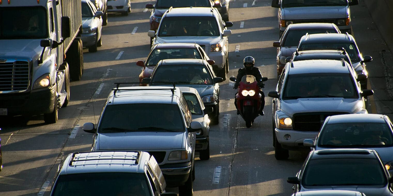 An image of a motorcyclist filtering through traffic.