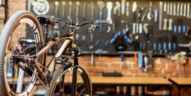 Mountain bike resting on bike stand in workshop with tools on wall