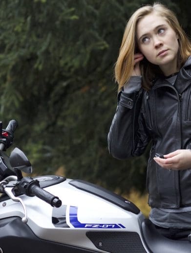 A woman installing earplugs before a ride. Media sourced from RideWell.