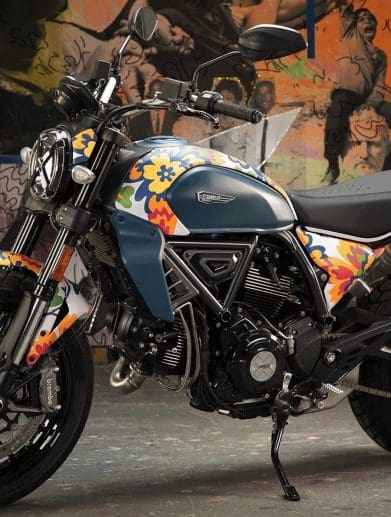 A view of Ducati's next-gen Scrambler Icon - a bike that's recently had a new livery scheme from RXART artist Mickalene Thomas, in support of art in children's hospitals. Media sourced from Ducati.