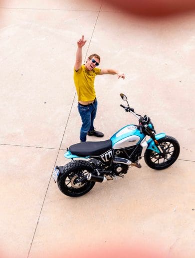 A model next to a Ducati Scrambler. Media sourced from Ducati.