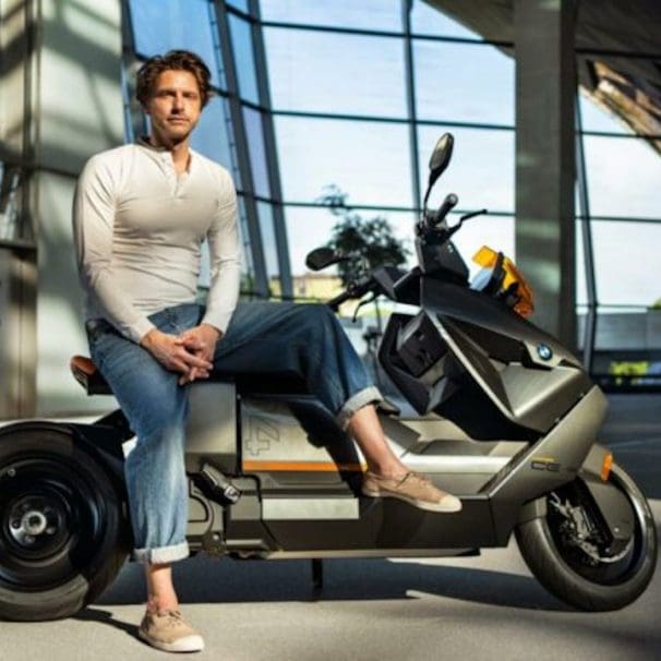 BMW's new Design Director, Alexander Buchan, sitting on one of his designs, the CE 04. Media sourced from BMW.