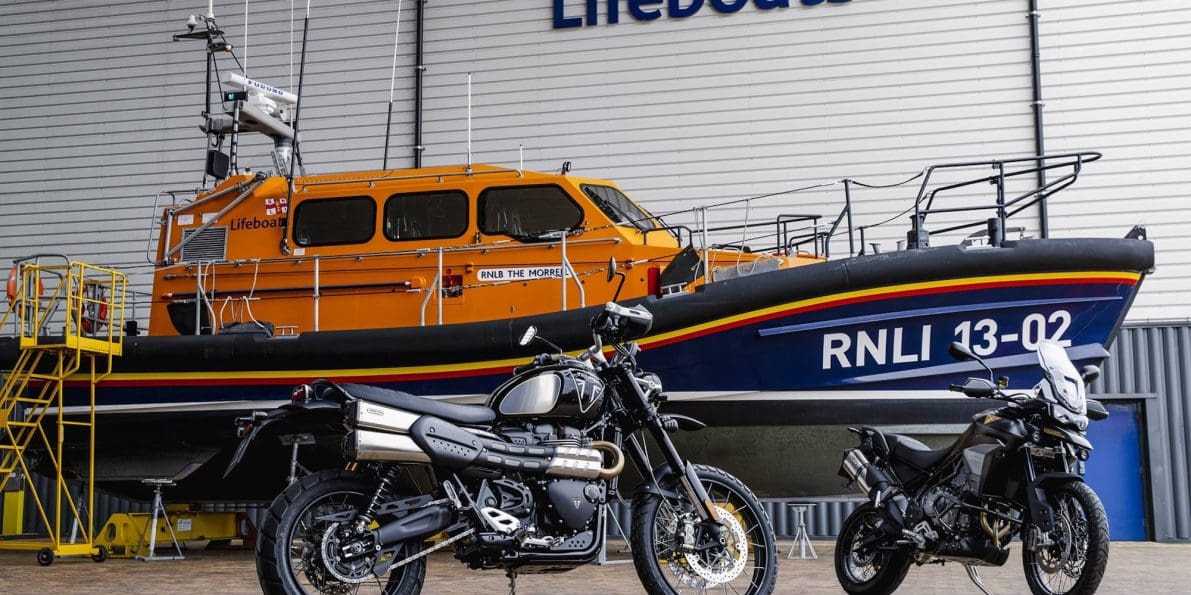 Two motorcycles in front of a boat.