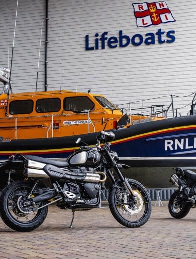 Two motorcycles in front of a boat.