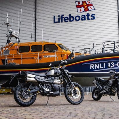 Two motorcycles in front of a boat.