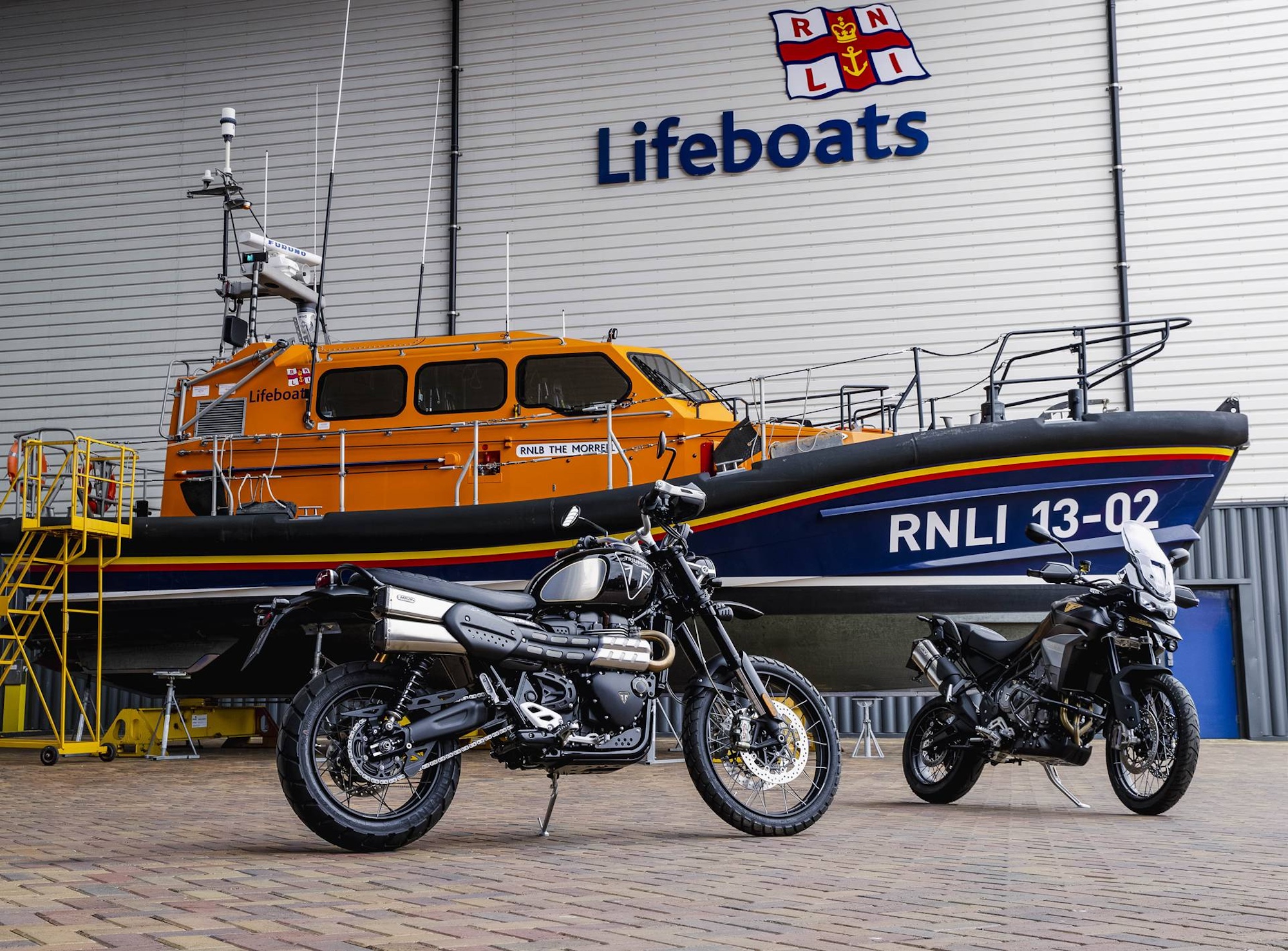 Two motorcycles in front of a boat.