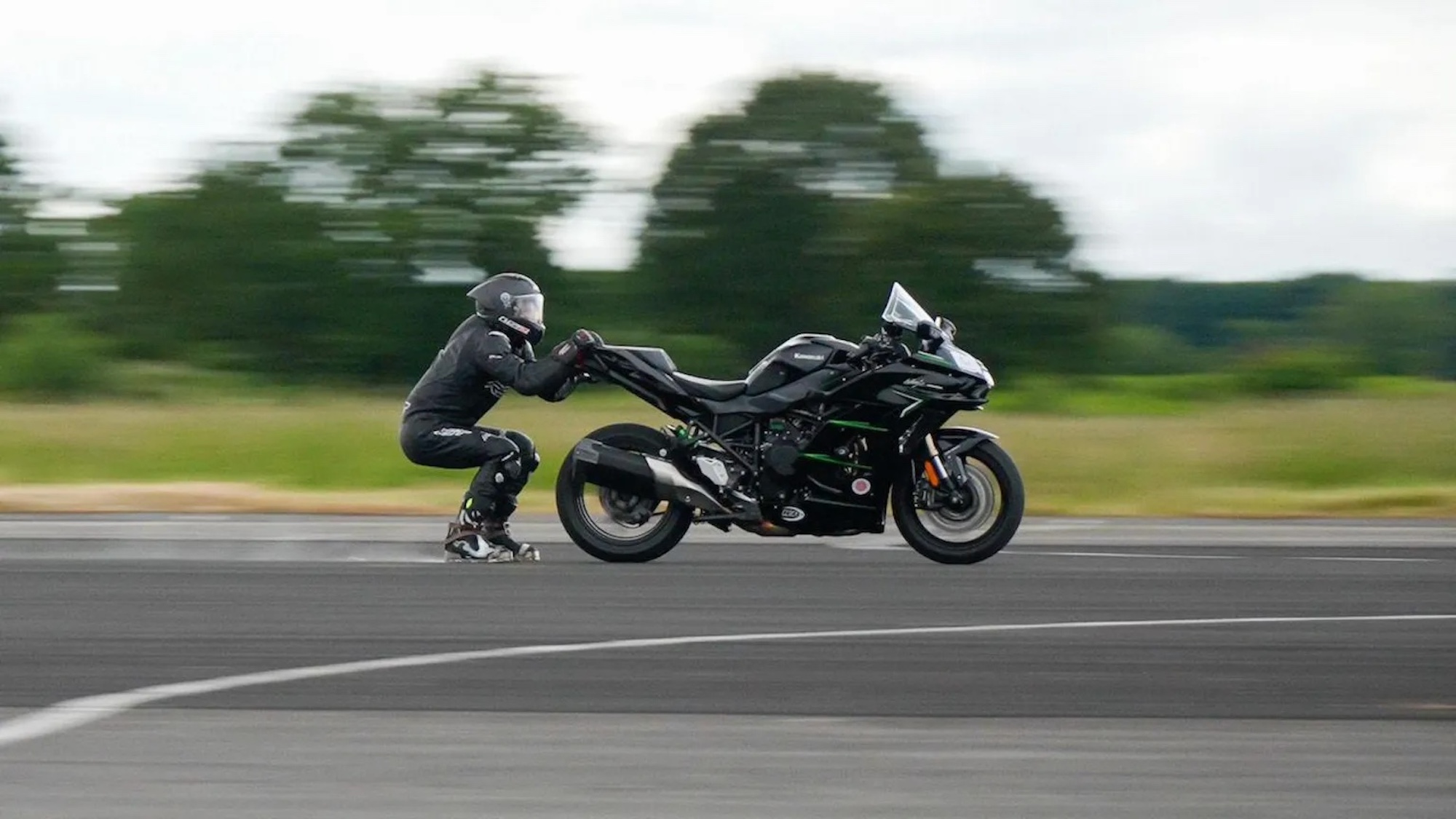 A man being dragged behind a motorcycle to break a world record.