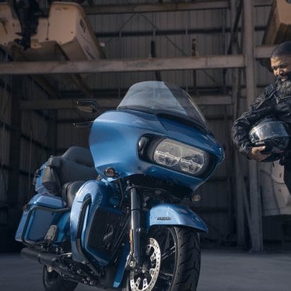 A front view of a man standing next to a Harley-Davidson's 2024 Road Glide Limited.